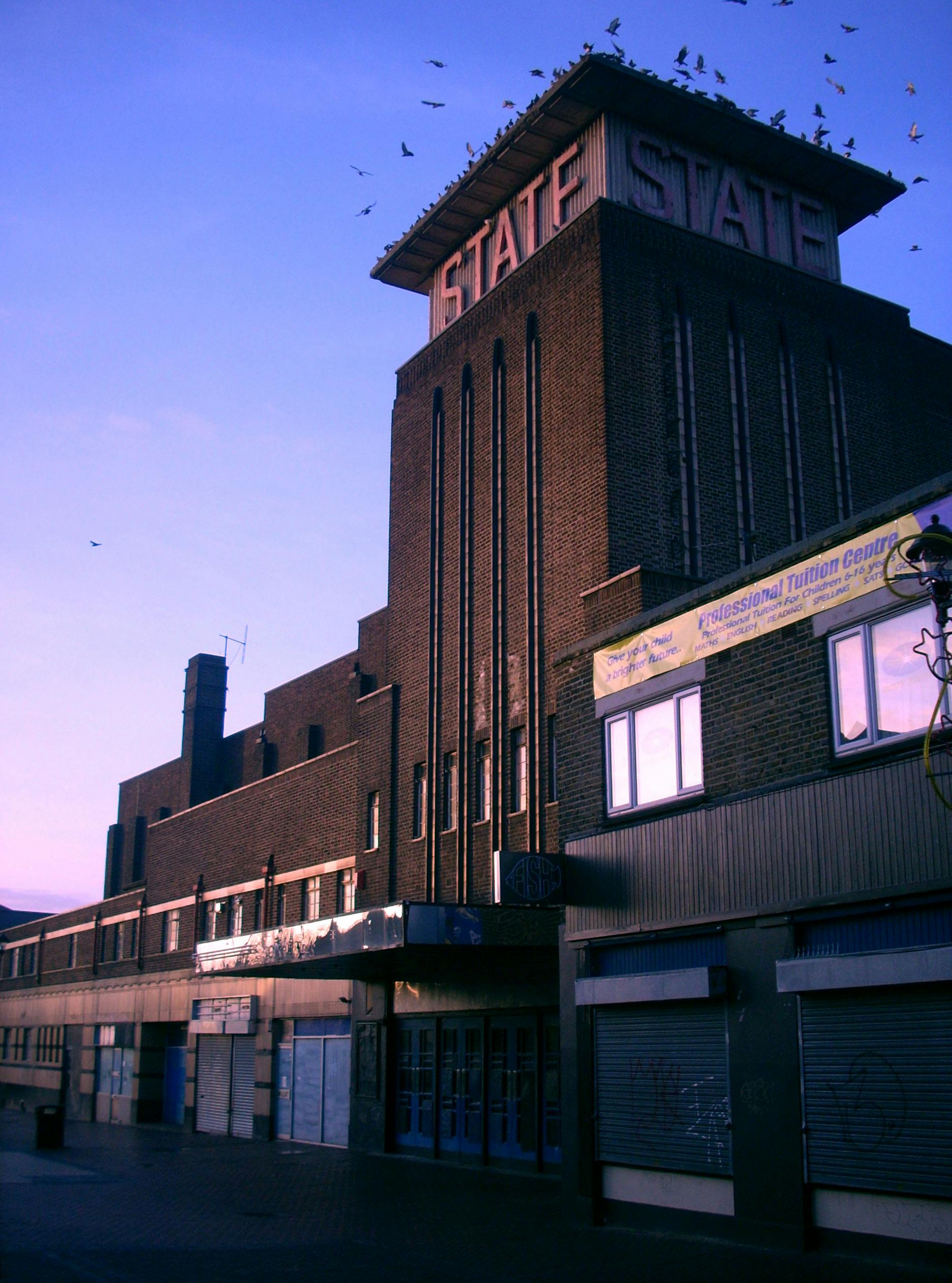 Captured at dusk, this historic brick theater with glowing signage stands as an iconic urban structure.